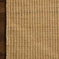 Top-down close-up showing rug edge and vertical stripe pattern on wooden floor