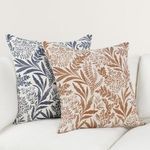 Two pillows side by side on sofa, Mulberry linen throw pillow alongside navy blue foliage pillow