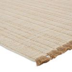 Close-up showing thick woven texture and natural fiber fringes on rug edge