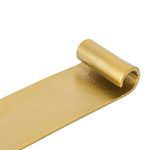 Close-up of one curled end with raw brass texture and hollow inside