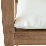 Close-up showing edge of white cushion resting on teak frame