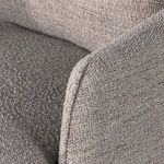 Detail of armrest and seat cushion seam with visible fabric texture in gray tones