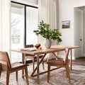 Round rug used in dining room setting beneath wood table and leather chairs