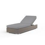 Adjustable outdoor chaise lounge with resin wicker frame in driftwood and light gray cushions, showing reclining backrest.