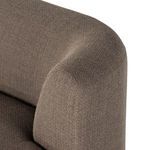 Close-up of sectional’s curved armrest and backrest junction in mink brown fabric