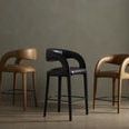 Row of three bar stools with Hawkins design featuring butterscotch and black leather variants