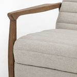 Close-up showing rounded wooden armrest meeting cushioned seat with herringbone fabric