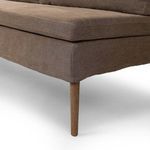 Close-up of front corner showing seat cushion layering and oak leg finish