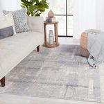 Lavato rug styled in living room setting with light gray sofa, wooden side table, and green plant