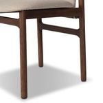 Close-up of chair’s front left leg and apron featuring smooth wood grain in dark finish