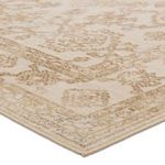 Close-up corner view showing detailed woven texture and clean edged binding of gold and ivory medallion rug