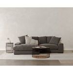 Front view of dark grey Plunge sectional styled with pillows and black wire coffee and side tables