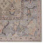 Close-up on rug border showing soft orange accents and detailed floral motifs