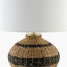 Round rattan accent table lamp with black horizontal stripes, white linen shade, and brass base