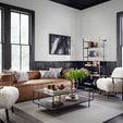 Nolita Reverse Stitch Sofa styled with pillows in a modern living room with tall black-framed windows and sheepskin armcha...