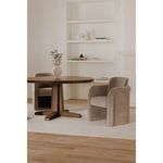 Dining room scene with beige Mesto chair beside round wooden table and light decor
