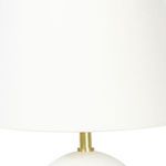 Close-up of tall natural linen lamp shade with visible texture and brass detail below