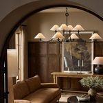 Renzo Chandelier illuminated in cozy room with wood paneling and linen shades