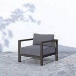 Sonoma Outdoor Chair shown outside on stone tile patio with shadowed white wall background