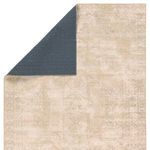 Back corner folded to reveal solid deep blue backing contrasting with tan and cream rug front