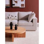 Folke round coffee table styled in a living room with black vases and a gray sofa against a red wall
