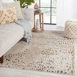 Kimball Animal rug styled in living room beside light sofa and round wooden side table with decorative objects