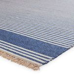 Close-up showing texture and tight weave of blue and beige striped rug with fringed edge