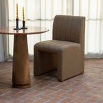 Sally Dining Chair positioned by round marble table with wood base, lit by sheer curtains in natural light