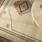 Close-up above view showing rug texture near round wood table corner.