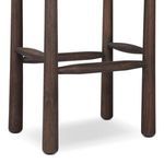 Close-up of dark wood tapered legs with rounded horizontal support bars of stool