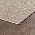 Corner of the rug on wood floor highlighting thin edge and flat weave texture