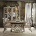 Dining table styled in room setting with six upholstered chairs, chandelier overhead, and natural light through sheer curt...