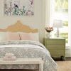 Bedroom context with Jesse Lamp on green nightstand, decorative flowers, and bed with patterned bedding and unique headboard