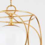 Close-up detail of gold metal framework and top fixture connecting the opal glass globe