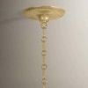 Close-up of textured gold ceiling mount and decorative chain links