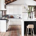 Narrow runner version of Layla Brick rug in kitchen setting beside white cabinets and wooden stool