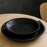 Sandblasted black bowls in a modern dining room setting on a light wood table