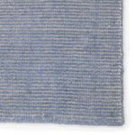 Close-up detail of rug’s textured weave blending light blue and cream fibers