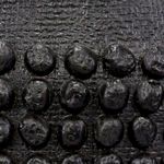 Close-up of the textured black resin surface with raised beaded details on the lamp base
