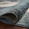 Edge view of rug rolled slightly showcasing tightly bound edges and dense pile construction