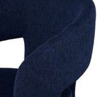 Close-up of textured True Blue polyester fabric on the curved armrest of the Anise Dining Chair