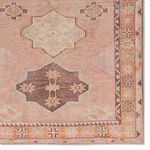 Close-up of corner detailing showing mini-medallion and intricate border design in faded hues