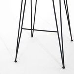 Close-up of metal stool legs and footrest bar with matte black finish