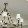 Katie Large Chandelier angled view in room with beige walls and curtain background