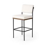 Benton Stool in three-quarter view highlighting black iron frame and plush white seat cushion with oak accent