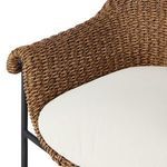 Close-up of cream upholstered seat cushion on woven outdoor stool frame