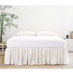 Gathered cream linen twin bed skirt with soft gathers around full bed base in light neutral bedroom setting