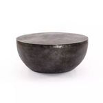 Aged grey aluminum drum coffee table with a smooth round top and curved base, sleek and minimalist design.