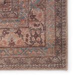 Close-up of rug border highlighting intricate design with muted blue and brown floral details