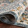 Rolled edge close-up emphasizing soft polyester pile and detailed weave on blue and sand rug